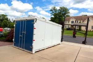 A portable storage container delivered to a residential driveway.